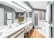 A well-lit bathroom featuring double sinks, a walk-in shower, and a separate bathtub for added convenience and luxury at 5090 White Pine Ne Cir, St Petersburg, FL 33702