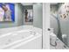 Elegant bathroom features a white jacuzzi tub, a uniquely painted tree on the wall, and decorative Parisian themed wall art at 5090 White Pine Ne Cir, St Petersburg, FL 33702
