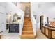 Staircase with wood steps, light walls, and decorative furniture in the entryway at 5090 White Pine Ne Cir, St Petersburg, FL 33702