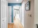 Bright hallway leading to a bathroom, featuring wood floors, white doors, and soft, neutral wall colors at 5090 White Pine Ne Cir, St Petersburg, FL 33702