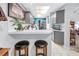 Kitchen area with bar seating, gray cabinets, modern appliances, and view into adjacent living space at 5090 White Pine Ne Cir, St Petersburg, FL 33702