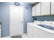 Efficient laundry room with modern appliances, storage cabinets, and a convenient exterior access door at 5090 White Pine Ne Cir, St Petersburg, FL 33702