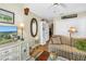 Cozy living room with hardwood floors, a striped sofa, and a decorative dresser, illuminated by a table lamp at 5090 White Pine Ne Cir, St Petersburg, FL 33702