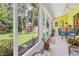 Screened lanai with table and chairs offering a view of the fenced backyard with mature landscaping at 5090 White Pine Ne Cir, St Petersburg, FL 33702