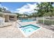 Community pool area with an inviting hot tub, lounge chairs, and lush landscaping, perfect for relaxation at 5090 White Pine Ne Cir, St Petersburg, FL 33702