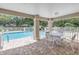 Community pool featuring a covered seating area with brick pavers and outdoor furniture near the shimmering water at 5090 White Pine Ne Cir, St Petersburg, FL 33702