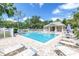 Community pool with lounge chairs surrounded by lush landscaping perfect for relaxation and leisure at 5090 White Pine Ne Cir, St Petersburg, FL 33702