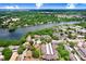 Aerial view showcases a picturesque lakefront community amidst lush greenery with a community pool at 5103 Puritan Cir # 5103, Tampa, FL 33617