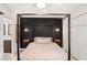 Spacious bedroom with a king size canopy bed, black accent wall, and modern bedside tables at 5103 Puritan Cir # 5103, Tampa, FL 33617