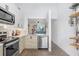 Bright modern kitchen features stainless appliances, white cabinets, quartz counters, and neutral backsplash at 5103 Puritan Cir # 5103, Tampa, FL 33617