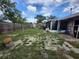 View of the home's backyard showing grass, a wooden fence, and a screened in porch at 5221 82Nd N Ave, Pinellas Park, FL 33781