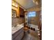 Bathroom featuring a shower-tub combo, floral wallpaper, and wooden cabinets at 5221 82Nd N Ave, Pinellas Park, FL 33781