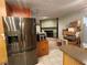 Kitchen area featuring modern stainless steel refrigerator, kitchen island, and direct view of cozy fireplace at 5221 82Nd N Ave, Pinellas Park, FL 33781
