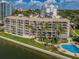 Beautiful aerial view of the condo complex with palm trees, and a blue swimming pool at 55 Rogers St # 502, Clearwater, FL 33756