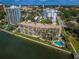 A captivating aerial view of a condo complex with palm trees, and a blue swimming pool at 55 Rogers St # 502, Clearwater, FL 33756