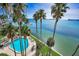 Aerial view featuring a blue pool surrounded by palm trees with expansive views of the bay at 55 Rogers St # 502, Clearwater, FL 33756