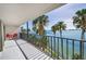 Balcony showcasing picturesque water views with palm trees and a seating area at 55 Rogers St # 502, Clearwater, FL 33756