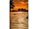 Golden sunset view over the water with palm trees, a passing boat and skyline at 55 Rogers St # 502, Clearwater, FL 33756