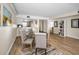 Bright dining area featuring a glass table set, hardwood flooring, and views into the kitchen at 55 Rogers St # 502, Clearwater, FL 33756