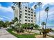 Modern condo building surrounded by lush landscaping and palm trees, offering a tropical paradise at 55 Rogers St # 502, Clearwater, FL 33756