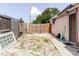 Backyard with a wood fence, a gate, partial brick walkway, and grass at 5601 Golden Dr, Tampa, FL 33634