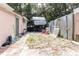 Backyard featuring a parked Pioneer trailer, partial brick walkway, and a metal fence at 5601 Golden Dr, Tampa, FL 33634