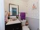 Charming half-bathroom with modern wallpaper, a sleek black vanity, and elegant fixtures at 5601 Golden Dr, Tampa, FL 33634