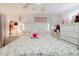 Cozy bedroom with a floral bedspread, ceiling fan, decorative lamps, and soft natural light at 5601 Golden Dr, Tampa, FL 33634