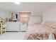 Bright bedroom featuring a decorative bedframe, plush pink bedding, and matching dresser with vanity mirror at 5601 Golden Dr, Tampa, FL 33634