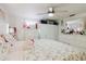 A bedroom with floral bedding, white furnishings, a ceiling fan, and overhead storage at 5601 Golden Dr, Tampa, FL 33634