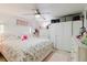 Well-lit bedroom showcasing a floral bedspread, a ceiling fan, and white closet storage at 5601 Golden Dr, Tampa, FL 33634