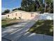 Charming pink brick home with a well-maintained lawn and a concrete driveway at 5601 Golden Dr, Tampa, FL 33634