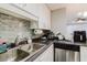 This kitchen features ample counter space, stainless steel sink, and tiled backsplash for food preparation and cleanup at 5601 Golden Dr, Tampa, FL 33634