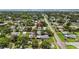 Aerial view showcasing a residential neighborhood featuring tree-lined streets, homes with various rooftops, and a coastal backdrop at 5725 18Th S Ave, Gulfport, FL 33707