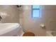 Bathroom with a white toilet, vanity, tiled floor, and a window bringing in natural light at 5725 18Th S Ave, Gulfport, FL 33707