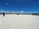 Expansive view of a white sandy beach on a bright sunny day with blue skies and a few fluffy clouds at 5725 18Th S Ave, Gulfport, FL 33707