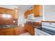 View of kitchen with wood cabinets, tile backsplash, stainless sink, and modern appliances at 5725 18Th S Ave, Gulfport, FL 33707