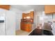 Traditional kitchen featuring wood cabinetry, stainless steel sink, and modern white refrigerator at 5725 18Th S Ave, Gulfport, FL 33707