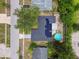 An aerial shot shows a home with solar panels, a refreshing pool, and mature trees in a residential neighborhood at 6200 13Th Ave, New Port Richey, FL 34653