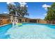 Backyard featuring swimming pool, fence, patio, and house with solar panels at 6200 13Th Ave, New Port Richey, FL 34653