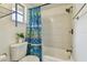 Bathroom with blue patterned shower curtain, shower, and plant on the toilet at 6200 13Th Ave, New Port Richey, FL 34653