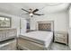 Well-lit bedroom features a queen-sized bed, a ceiling fan, and a dresser at 6200 13Th Ave, New Port Richey, FL 34653