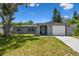 Charming single-story home features stone accents, a well-maintained lawn, and a driveway leading to an attached garage at 6200 13Th Ave, New Port Richey, FL 34653