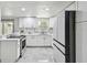Contemporary kitchen design features white cabinetry, marble backsplash, and modern appliances, offering a sleek aesthetic at 6200 13Th Ave, New Port Richey, FL 34653