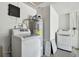Bright laundry room with a new washer, dryer, and water heater at 6200 13Th Ave, New Port Richey, FL 34653