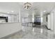 Open floor plan showing kitchen, dining, and living area with marble floors and natural light at 6200 13Th Ave, New Port Richey, FL 34653