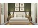 Cozy bedroom showcasing a queen bed, and stylish decor with a muted green accent wall and butterfly artwork at 6611 Active Run, New Port Richey, FL 34653