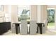 Elegant dining room with seating for four, featuring stylish chairs, a wooden table, and modern decor at 6611 Active Run, New Port Richey, FL 34653