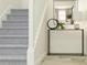 Inviting entryway featuring a console table with decor and stairs with light gray carpet at 6611 Active Run, New Port Richey, FL 34653
