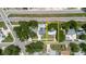 Aerial view of the property with a pool on the adjacent lot, highlighted by mature trees and the neighborhood at 706 E Gate Dr, Safety Harbor, FL 34695